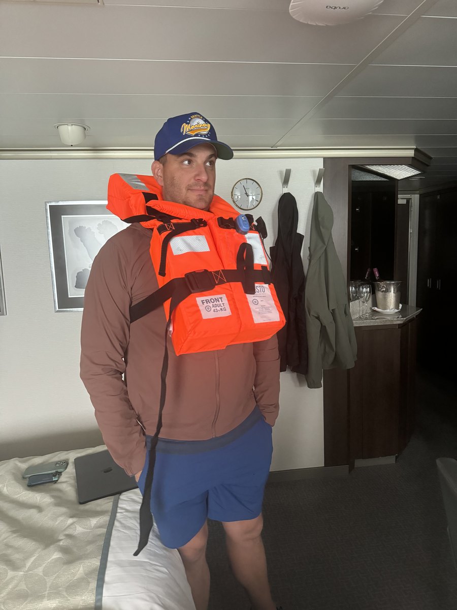 Bryce Morgan wearing a life vest indoors on a cruise ship